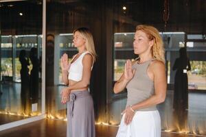 deux magnifique femmes sont Faire yoga permanent en haut dans le aptitude pièce photo