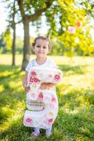 de bonne humeur fille ayant amusement sur enfant anniversaire sur couverture avec papier décorations dans le parc photo