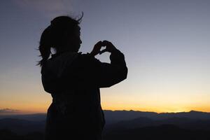 silhouette de femme prier à Dieu le plus élevé Foi dans religion et croyance dans Dieu basé sur prière. le Puissance de espérer ou l'amour et dévouement. photo