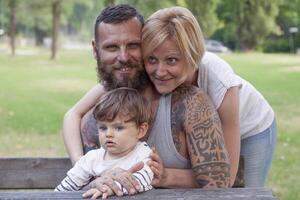 Jeune couple avec enfant ayant amusement à le parc photo