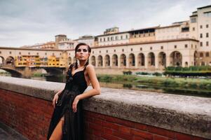 une magnifique élégant la mariée dans une noir robe des promenades par Florence, une modèle dans une noir robe dans le vieux ville de Italie photo