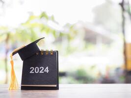 étude buts, 2024 bureau calendrier avec l'obtention du diplôme chapeau. le concept pour résolution, but, action, planification, et gérer temps à Succès diplômé. photo