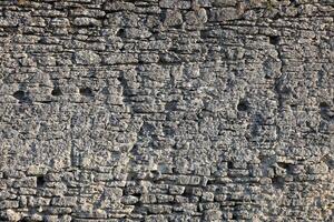 très vieux brique pierre mur de Château ou forteresse de 18e siècle. plein Cadre mur avec obsolète sale et fissuré briques photo