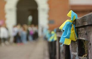 rubans dans le couleurs de le nationale drapeau de Ukraine sont lié à le balustrade photo