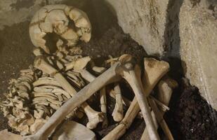 crâne et des os creusé de fosse dans le effrayant cimetière de les prisonniers photo