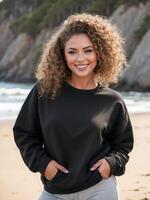 ai généré femme dans une noir sweat-shirt et gris un pantalon des stands sur une sablonneux plage avec le océan et rocheux falaises dans le Contexte photo