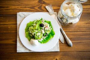 Frais été salade avec de bonne heure chou, concombres, des radis et autre des légumes dans une assiette photo