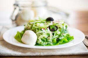 Frais été salade avec de bonne heure chou, concombres, des radis et autre des légumes dans une assiette photo