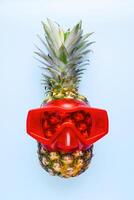 ananas avec plongée des lunettes de protection sur bleu Contexte photo