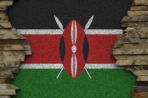 Kenya drapeau représenté dans peindre couleurs sur vieux pierre mur fermer. texturé bannière sur Roche mur Contexte photo