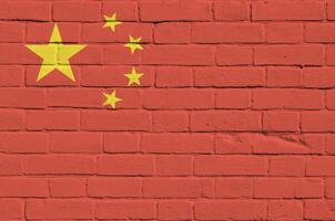 Chine drapeau représenté dans peindre couleurs sur vieux brique mur. texturé bannière sur gros brique mur maçonnerie Contexte photo