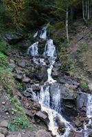 une Montagne cascade les flux plus de le rochers. cascade Cascade sur moussu rochers photo