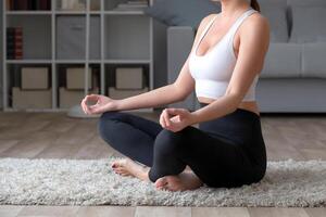 sportif Jeune femme pratiquant yoga à maison, séance dans lotus pose photo