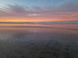 le coucher du soleil à playa de famara, lanzarote, des peintures le ciel avec vibrant teintes, moulage une fascinant lueur plus de le horizon. Stupéfiant vue cette capture le essence de tranquillité et Naturel beauté. photo