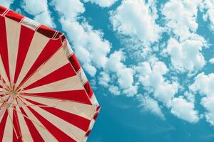 ai généré fermer de rayé plage parapluie avec bleu ciel dans le Contexte. génératif ai photo