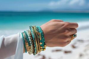 ai généré femme main avec sarcelle bracelets sur une le sable plage Contexte. génératif ai photo