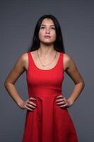 studio portrait de une Jeune magnifique fille dans une rouge robe 3 photo