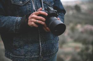 fermer professionnel caméra dans le mains de Masculin voyageur photographe photo