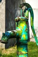 vieux main l'eau pompe sur une bien dans le jardin, arrosage et économie eau, rural environnement photo