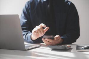 côté vue coup de une homme mains en utilisant intelligent téléphone dans intérieur, arrière vue de affaires homme mains occupé en utilisant cellule téléphone à Bureau bureau, Jeune Masculin étudiant dactylographie sur téléphone séance à en bois tableau, éclater photo