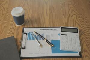 proche en haut vue de Facile espace de travail avec ordinateur portable, des cahiers, café tasse et arbre pot sur blanc table avec flou Bureau pièce Contexte photo