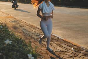 Jeune aptitude femme coureur élongation jambes avant courir sur ville photo