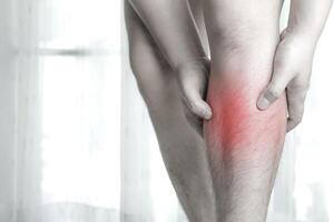 blessure au tibia. main masculine tenant la jambe avant avec douleur au tibia. concept de soins de santé, douleurs musculaires induites par l'exercice, os de la jambe blessé photo