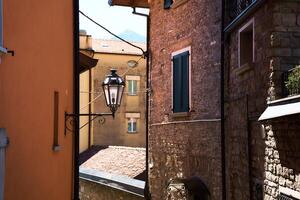 lanterne entre Maisons avec fermé volets dans italien été ville, détail, Contexte photo