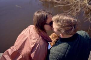 une Jeune couple avec une chien embrasser sur le jetée photo