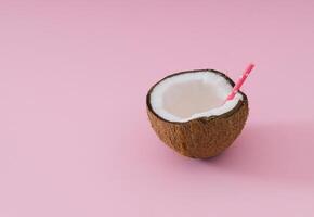 tropical plage concept fabriqué de noix de coco fruit et en buvant paille sur lumière rose Contexte. Créatif été idée. minimal noix de coco composition. photo