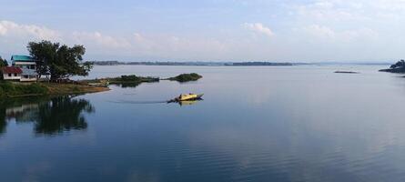 une bateau est flottant sur une Lac près une petit village photo