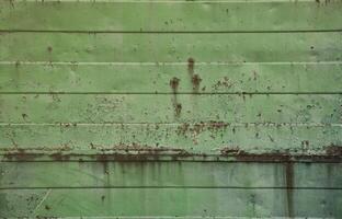 texture d'un vieux mur de métal vert avec des dommages importants dus à l'exposition à des conditions météorologiques défavorables et à l'humidité photo