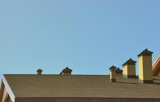 toiture moderne et décoration de cheminées. bardeaux souples en bitume ou en ardoise. l'absence de corrosion et de condensation grâce au toit souple photo