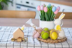 clé et minuscule maison de confortable Accueil avec Pâques décor avec lapin et des œufs sur table de cuisine. bâtiment, conception, projet, en mouvement à Nouveau loger, hypothèque, assurance, location et achat réel biens photo