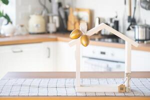 clé et minuscule maison de confortable Accueil avec Pâques décor avec Couleur des œufs sur table de cuisine. bâtiment, conception, projet, en mouvement à Nouveau loger, hypothèque, assurance, location et achat réel biens photo