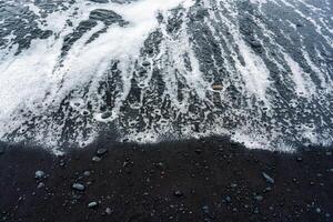mer vague sur volcanique noir le sable plage dans été photo