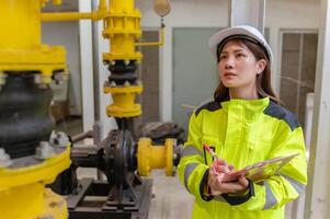 entretien technicien à une chauffage usine, pétrochimie ouvriers superviser le opération de gaz et pétrole pipelines dans le usine, ingénieurs mettre audition protecteur à pièce avec beaucoup tuyaux photo