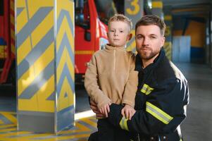 sapeur pompier en portant enfant garçon à enregistrer lui dans Feu et fumée, pompiers porter secours le garçons de Feu photo