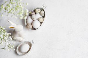monochrome blanc Pâques carte ou invitation. Naturel Couleur œufs, céramique lapin, gypsophile fleurs. photo