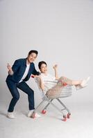 content souriant couple pousser supermarché Chariot isolé sur blanc Contexte photo