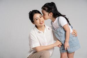 portrait de un asiatique mère et fille posant sur une blanc Contexte photo