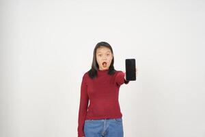 Jeune asiatique femme dans rouge T-shirt sensationnel sous le choc et montrant téléphone intelligent Vide écran isolé sur blanc Contexte photo