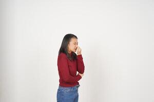 Jeune asiatique femme dans rouge T-shirt odeur quelque chose puant et répugnant isolé sur blanc Contexte photo