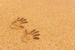 impressions de deux aux femmes mains sur d'or mer sable. mer vacances symbole. photo