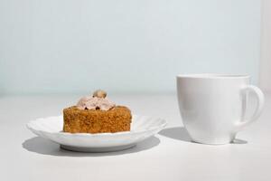 tasse de thé et gâteau décoré avec crème et des noisettes. Matin petit déjeuner avec dessert dans le cuisine. photo