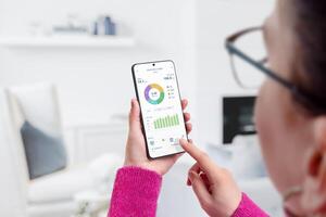 femme les usages électricité usage app pour consommation surveillance et une analyse dans vivant chambre. concept de énergie la gestion et intelligent vivant photo