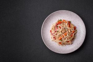 délicieux riz nouilles ou udon avec poulet, carottes, poivre, sel, épices et herbes photo