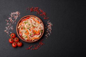 délicieux riz nouilles ou udon avec poulet, carottes, poivre, sel, épices et herbes photo