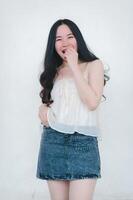 magnifique asiatique femme pose dans mode style, blanc chemise, jeans jupe. photo