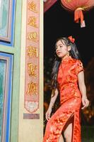 asiatique magnifique femme robe dans chinois style, chinois Nouveau année Festival à nuit photo